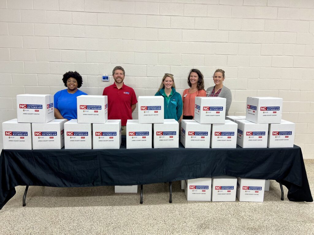 Jones Extension staff posing behind Food Boxes during the Holiday Food Safety Class. (Left to right) Emoni Burgess, Jacob Morgan, Samantha Bennett, Sarah Ware, and Margaret Ross
